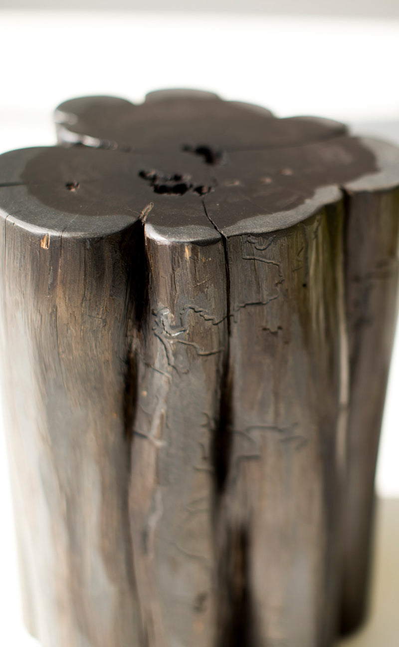 Modern luxury black stump side table beside a lounge chair